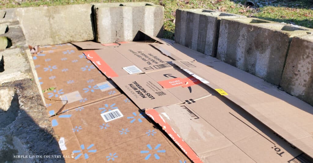 a layer of cardboard on the ground with a cinder block border 