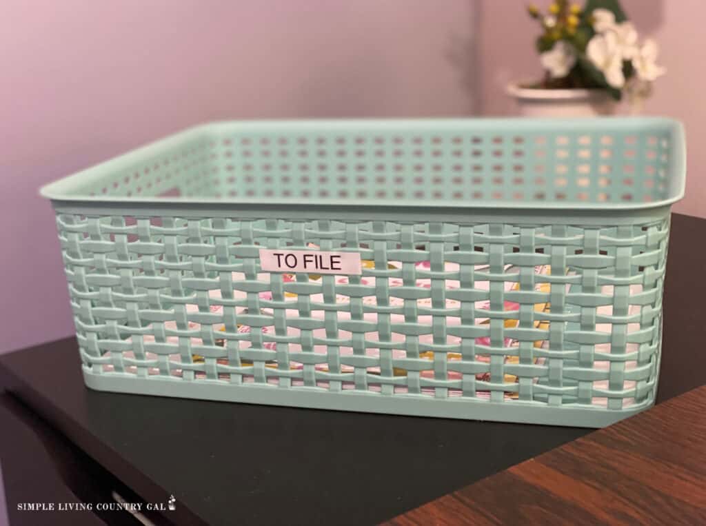 a teal basket labeled to file on an office desk