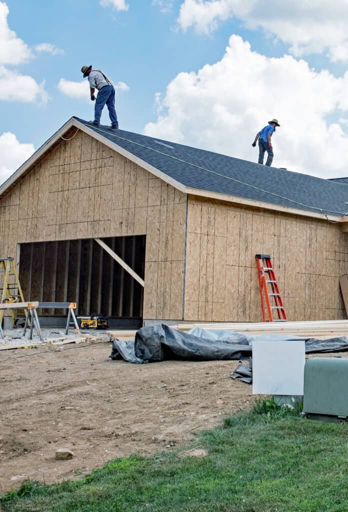 amish putting on a new roof on a garage