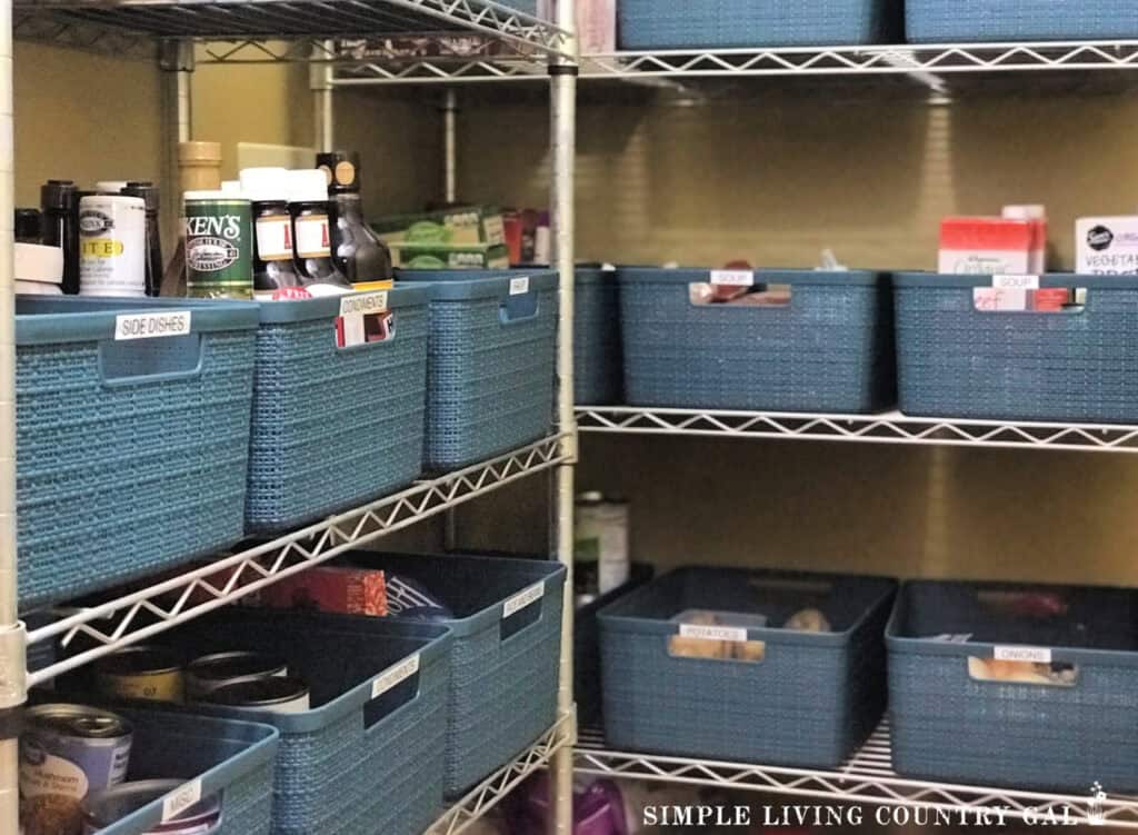 Organized pantry shelves with blue baskets labeled "Side Dishes," "Condiments," and "Soup"