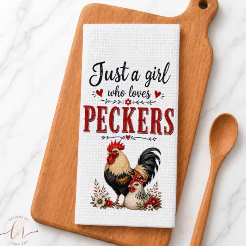 A chicken towel on a cutting board next to a wooden spoon