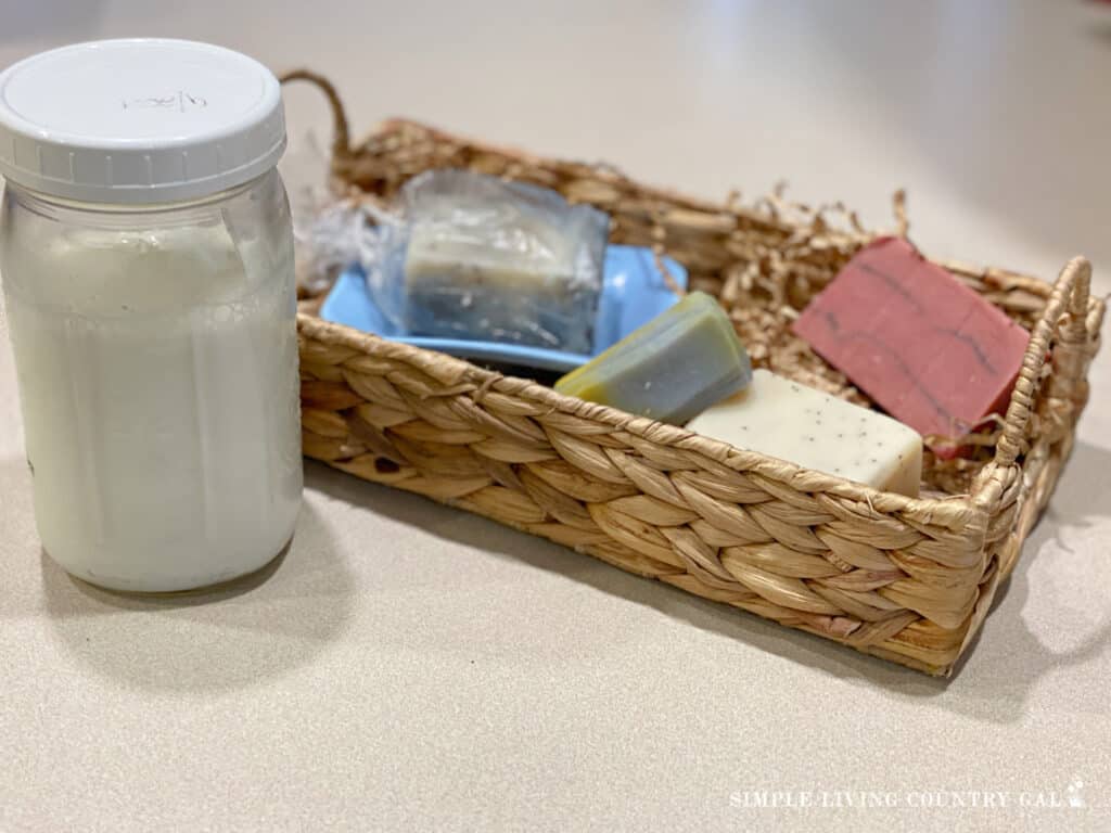 a jar of milk next to a basket of homemade soap