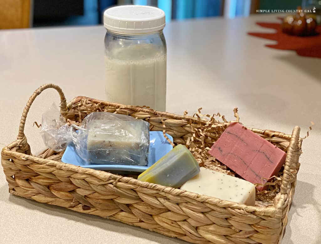 a jar of goat milk behind a basket of soaps
