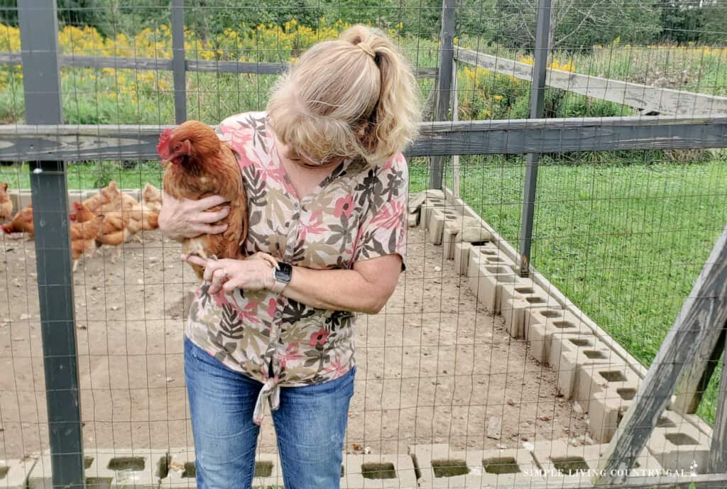 a woman holding a chicken