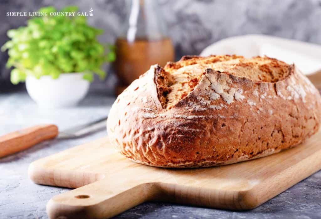 A fresh loaf of bread on a cutting board in a kitchen