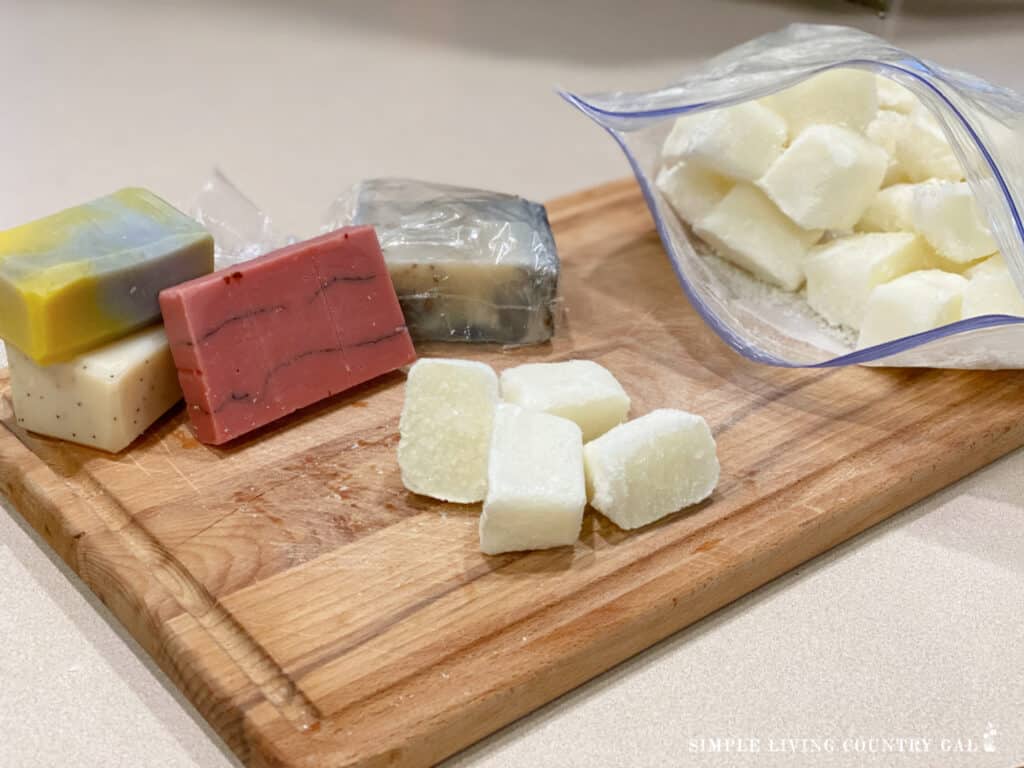 frozen goat milk on a cutting board next to bars of soap