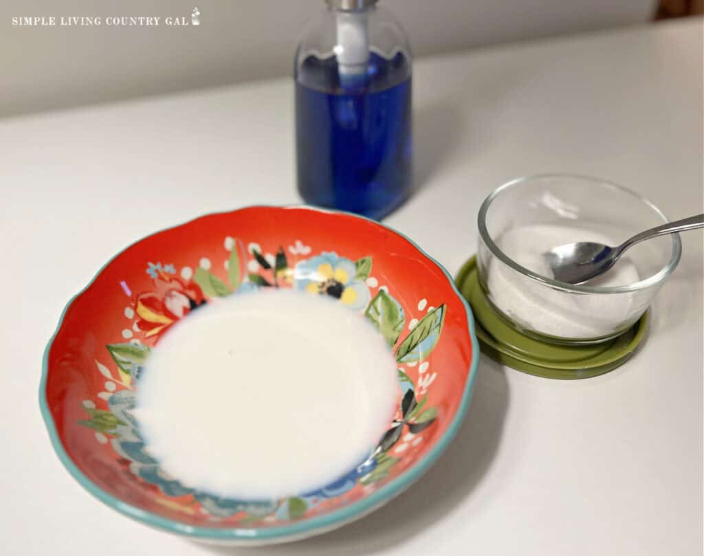 milk in a bowl next to sugar and soap for a fruit fly trap