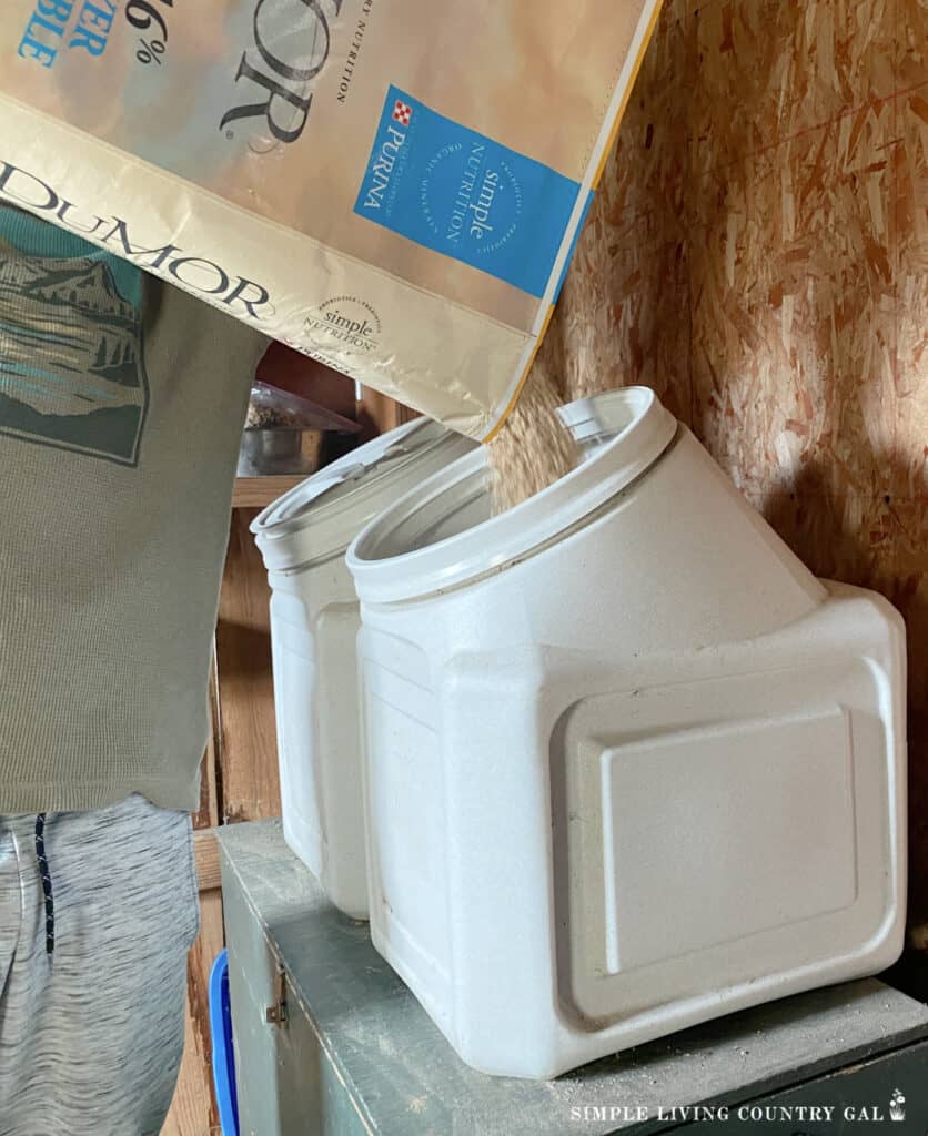 pouring feed into plastic storage containers