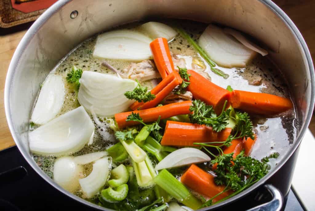 Veggies cooking in a stockpot to repurpose for broth