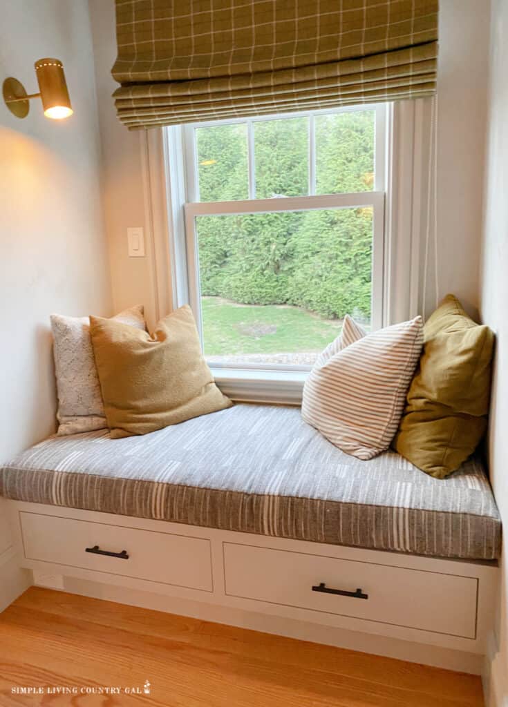 a cozy window seat with pillows and lighting