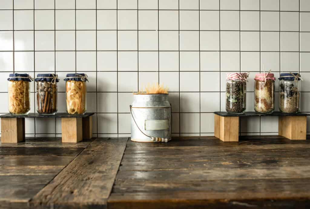 a rustic wood counter with jars of food