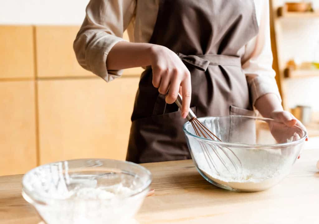 an Amish woman making fresh bed in a simple kitchen