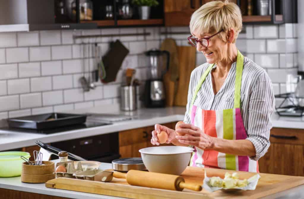 a mature woman making bread at a kitchen counter
