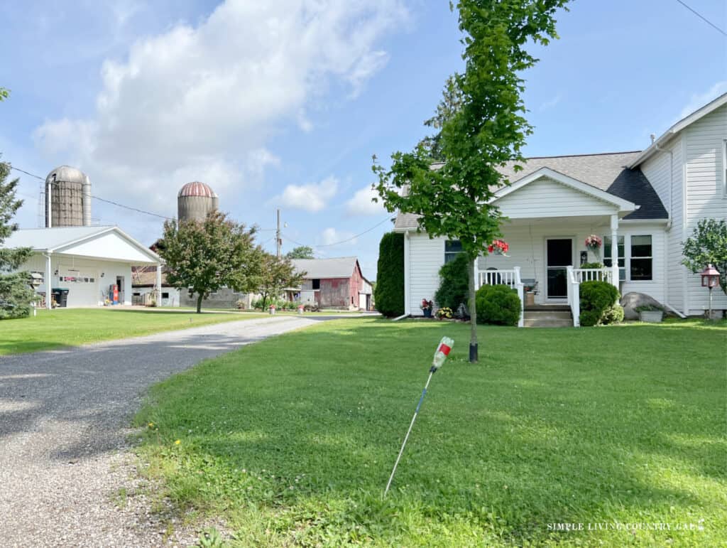 An Amish home, white house, white garage, gravel driveway